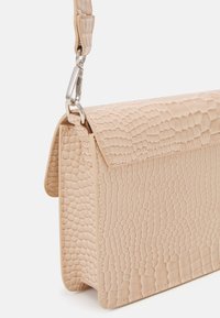 Borsa a spalla in finta pelle beige con una texture a motivo rettile, dotata di chiusura a patta e dettagli in metallo argentato.
