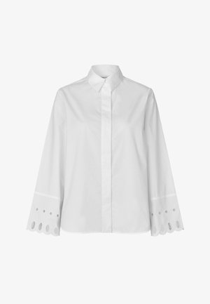 Biała bluzka z długim rękawem, kołnierzykiem na guziki, z haftowanymi ażurowymi zdobieniami na mankietach i prostym dołem.