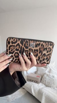 Portofel cu imprimeu leopard, cu suprafață texturată, închidere cu fermoar și detaliu logo transparent. Predominant maro cu pete negre.