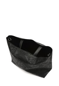 Črna torba iz teksturirane umetne usnje, s ptičastim cvetličnim vzorcem. Zgornji del je odprt in ima dve močni ročki za enostavno nošenje.