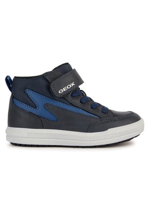 Sneaker alte con sopra in pelle grigia scura e tessuto blu. Presentano un cinturino in velcro, accenti blu e una suola in gomma bianca con grip texturizzato.