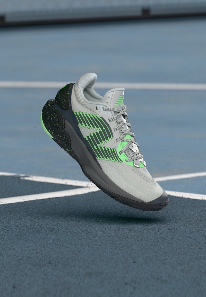 Grå og grøn atletisk løbesko hængende over en blå tennisbane med hvide linjer.