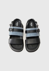 Par af sorte sandaler med denim- og læderremme, sølvspænder og Moschino Milano branding på indersålen.
