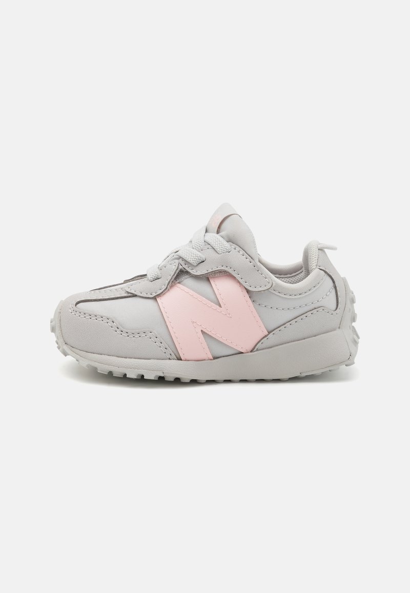 Grey sneaker with a pink "N" logo, featuring a textured upper, laces, padded collar, and a rubber outsole with traction pattern.