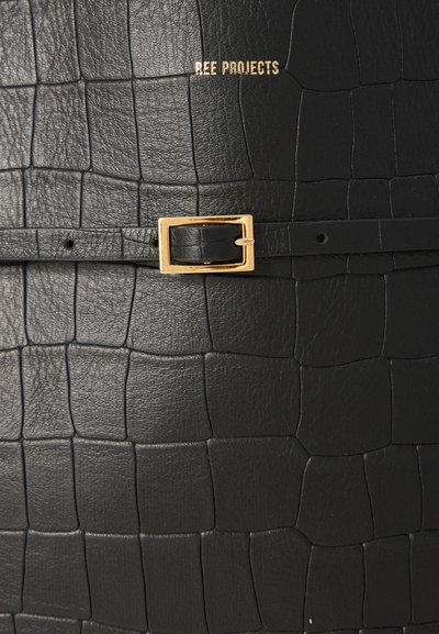 Bolso de cuero negro con textura de cocodrilo, herrajes de hebilla dorada y logotipo en relieve "REE PROJECTS".