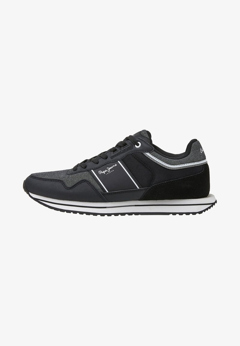Black athletic shoes with a mix of mesh and suede materials. Features white stripes and branding, flat sole with a textured tread design.