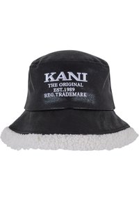 Sort bucket hat lavet af kunstlæder med en hvid fleece-brim. Har broderet hvid tekst, der siger "KANI THE ORIGINAL EST. 1989."