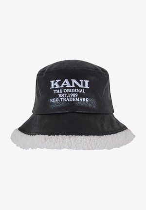 Schwarzer Bucket Hat aus Kunstleder mit einem weißen Fleece-Schrägschaft. Mit gesticktem weißen Text "KANI THE ORIGINAL EST. 1989."
