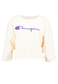 Cremfarbener, oversized, verkürzter Sweatshirt mit rundem Halsausschnitt und lockeren Ärmeln. Mit gesticktem "Champion"-Logo in Blau.