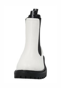 Botte Chelsea blanche avec panneaux latéraux élastiques noirs, semelle en caoutchouc texturée et languette de tirage marquée "paladdo". Tige en cuir lisse.