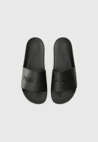 Sandale negre tip slip-on, fabricate dintr-un material sintetic neted. Caracteristici: o banda largă cu design-ul embosat "VALENTINO". Talpă plată, stil minimalist.