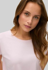 Lys pink ribbet t-shirt med en blød tekstur og rund halsudskæring. Har korte ærmer og en afslappet pasform, velegnet til afslappet brug.