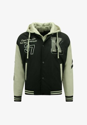 Zwart-witte varsityjas met capuchon, voorzien van geborduurde letters en cijfers, kenmerkende strepen op de manchetten en zoom.