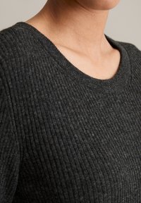 Dunkelgrauer, gerippter Pullover mit rundem Ausschnitt und strukturiertem Stoff, der vertikale Muster und eine weiche Oberfläche hervorhebt.