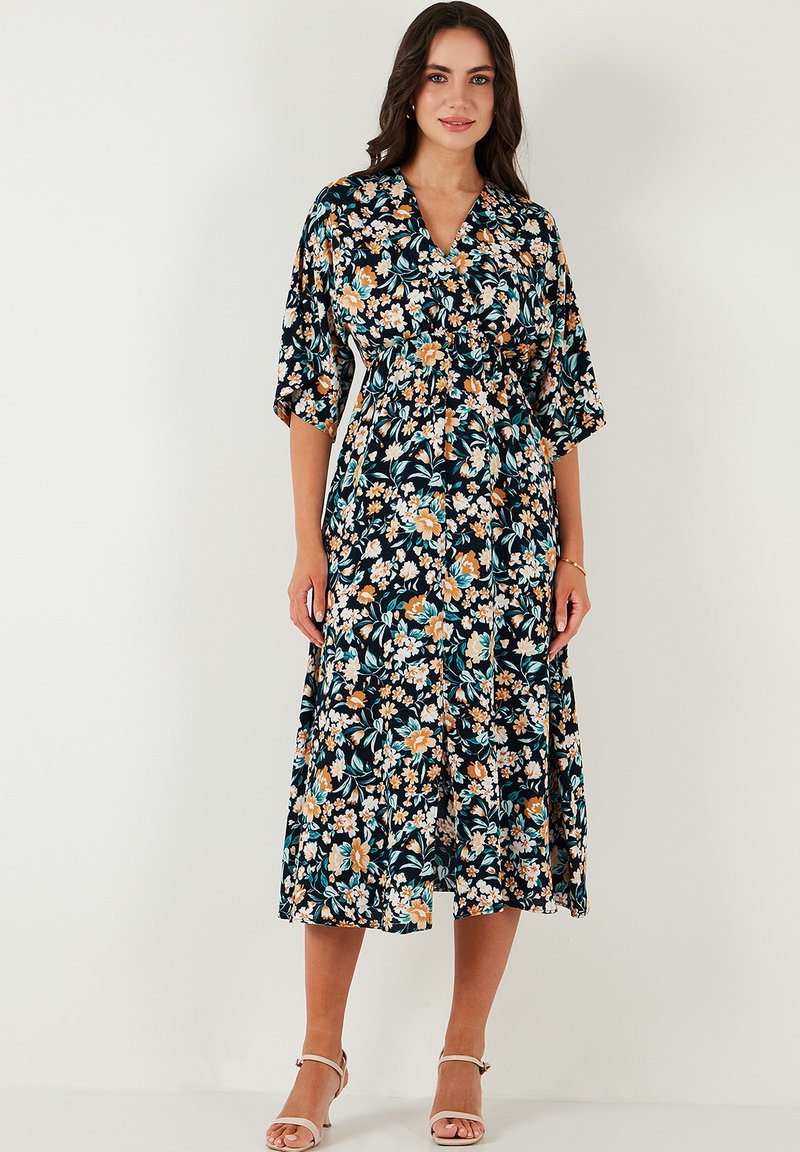 Blumen-Midi-Kleid aus schwarzem Stoff mit lebhaften Mustern in Orange, Blau und Weiß, mit kurzen Ärmeln und tailliertem Schnitt.