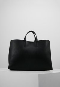 Czarna skórzana torba tote o teksturowanej powierzchni, z dwoma mocnymi uchwytami i otwartą górą. Prostokątny kształt z płaskim dnem.