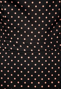 Černá látka s rovnoměrně rozmístěnými růžovými puntíky. Hladká textura bez výrazných vzorů nebo viditelného kovového hardwaru. Střih přizpůsobený postavě.