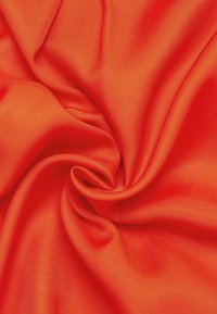 Lys orange stof, glat tekstur og satinfinish, arrangeret i bløde folder, der fremviser sin livlige farve og lette draperingsegenskaber.
