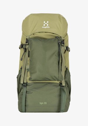 Duffel-stijl rugzak in groene tinten, voorzien van verstelbare banden, meerdere zakken en een bovenflap. Het materiaal is duurzaam en heeft textuuraccenten.