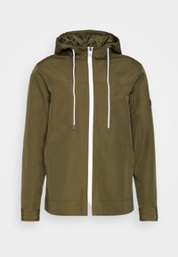 Chaqueta con capucha verde oliva y cremallera blanca, con dos bolsillos frontales y detalles de cordón. Fabricada con un tejido suave y ligero.
