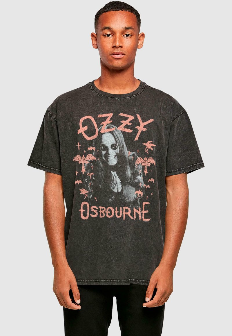 Tricou negru din bumbac, oversized, cu un imprimeu grafic care prezintă un bărbat cu păr lung și ochelari de soare, textul spune "OZZY" și "OSBOURNE" în roz.
