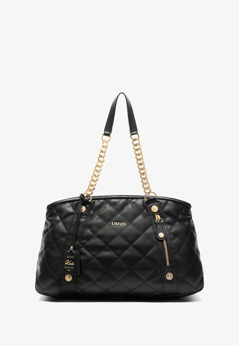 Borsa tote nera trapuntata in materiale sintetico con hardware dorato, dettagli in catena e un'etichetta in pelle con il nome del marchio e dettagli del design.