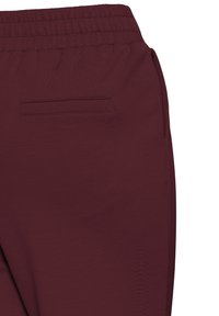 Pantalones de chándal burdeos con una cintura elástica, que cuentan con un bolsillo trasero y una textura suave. Diseño casual para comodidad y facilidad de movimiento.