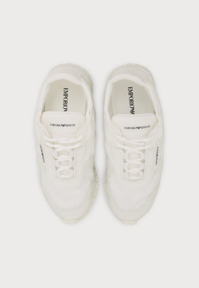 Paire de baskets blanches Emporio Armani avec lacets vue de dessus sur fond blanc.