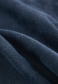 Țesătură de culoare albastru închis, cu o textură moale și un model de țesătură cu pliuri subtile, creând umbre și lumini vizibile.