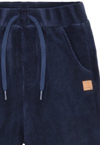 Marineblaue Cordshorts mit elastischem Bund, verstellbarem Kordelzug, Seitentasche und einem braunen Lederlogo-Patch auf der Vorderseite.
