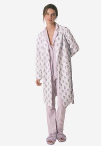 Hvid badekåbe med blomsterprint over pink og hvid stribet nattøjssæt, med bløde, plyssede hjemmesko. Stoffet virker let og hyggeligt.