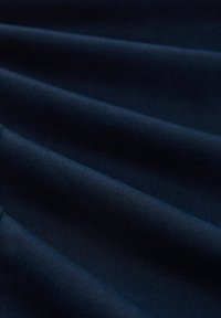 Navyblauer Stoff, der eine sanfte Textur mit sanften Wellen zeigt. Das Material wirkt weich und hat einen leicht schimmernden Finish.
