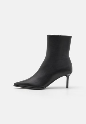 Black leather ankle boot with pointed toe and slim mid-height stiletto heel, set against a plain white background.