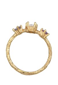 Guldring med en texturerad ring, med en central klar sten och två mindre lila stenar, satta i kloliknande klor.
