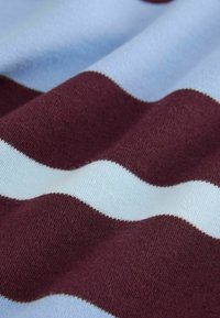 Țesătură moale cu dungi orizontale late alternante în albastru deschis și burgund închis, prezentând o textură detaliată tricotată.