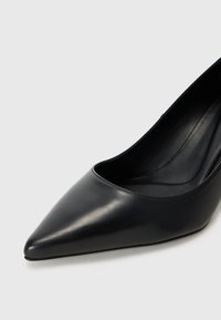 Scarpa nera con tacco alto in pelle liscia, con punta affusolata e un'apertura ampia. Il design del tacco è snello, esaltando la silhouette complessiva.