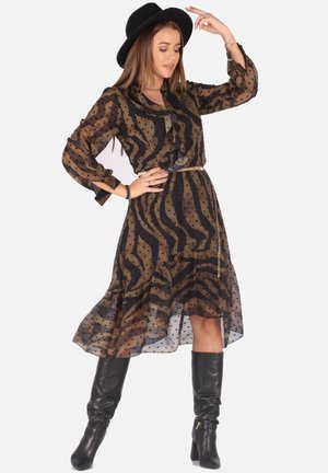 Durchsichtiges schwarzes und braunes Kleid mit Polka-Dots und Zebra-Muster, langen Ärmeln, rüschigem Kragen, tailliertem Bund mit einem goldenen Kettengürtel und einem fließenden Saum.