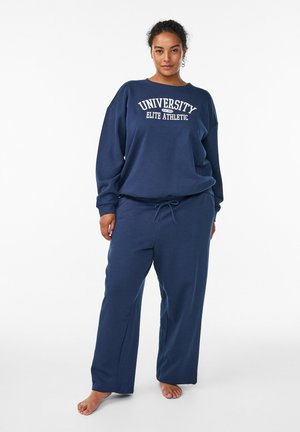 Dunkelblauer Sweatshirt und passende Sweatpants aus weichem Stoff. Das Sweatshirt trägt den Aufdruck "UNIVERSITY ELITE ATHLETIC". Die Hose verfügt über einen Kordelzug.