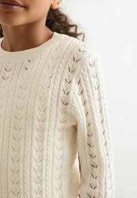 Hellbeige gestrickter Pullover mit Zopfmuster, geripptem Ausschnitt und aufwendigem Durchbrüche-Design im gesamten Stoff.