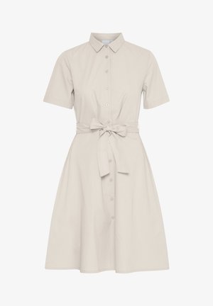 Vestido de manga corta, color beige claro, con frente abotonado, cuello y cinturilla. Presenta una falda acampanada y está hecho de una suave tela de algodón.