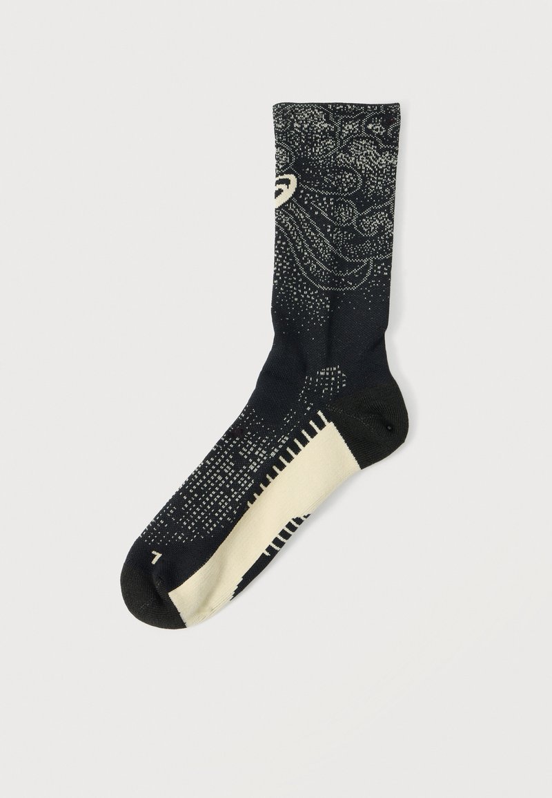 Black and cream mid-calf sock with abstract dotted wave and line patterns and a contrasting cream sole section.