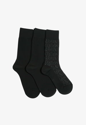 Trzy pary czarnych skarpetek wykonanych z gładkiej tkaniny. Jedna para ma subtelny wzór powtarzających się logo, pozostałe są jednolicie czarne.