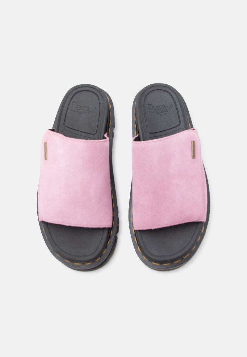 Paar schwarze Sandalen mit breiten rosa Wildlederriemen und gelber Ziernaht, von oben auf weißem Hintergrund gesehen.