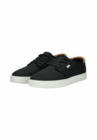 Sneakers neri in tela con suole in gomma bianche, con punte rotonde, lacci piatti e un dettaglio sul tallone marrone. Design semplice e minimalista.