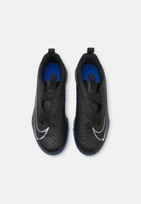 Mustat urheilukengät, joissa sininen sisäpuoli, tyylikäs muotoilu, teksturoitu pinta ja näkyvä valkoinen Nike-logo. Kengissä on joustavat nauhat ja vetokahvat.