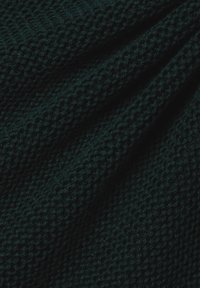 Dunkelgrüner gestrickter Stoff mit einer strukturierten Oberfläche. Das Material zeigt ein gewebtes Muster und weiche, leicht fuzzy Fasern.