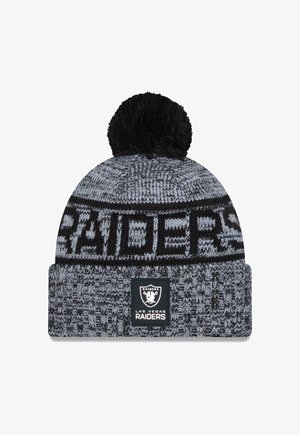 Black and gray knit beanie with a pom-pom top, featuring woven "RAIDERS" text and a logo patch at the cuff, textured pattern throughout.