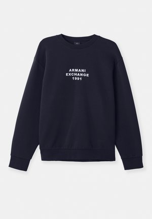 Sötétkék pulóver hosszú ujjakkal, kerek nyakkal és bordás mandzsettával. Az elején fehér "ARMANI EXCHANGE 1991" felirat látható.