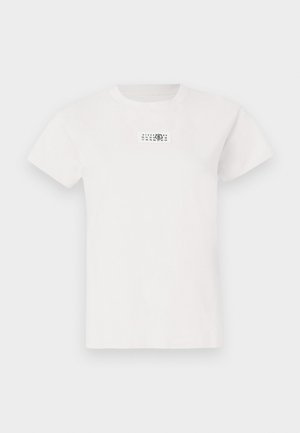 White cotton t-shirt with short sleeves, round neck, and a rectangular black and white graphic label on the chest. Soft texture.