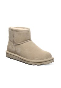 Beige Wildleder-Ankle Boots mit weichem Futter, genähten Details und einer dicken Gummisohle mit einem wellenförmigen Profil.